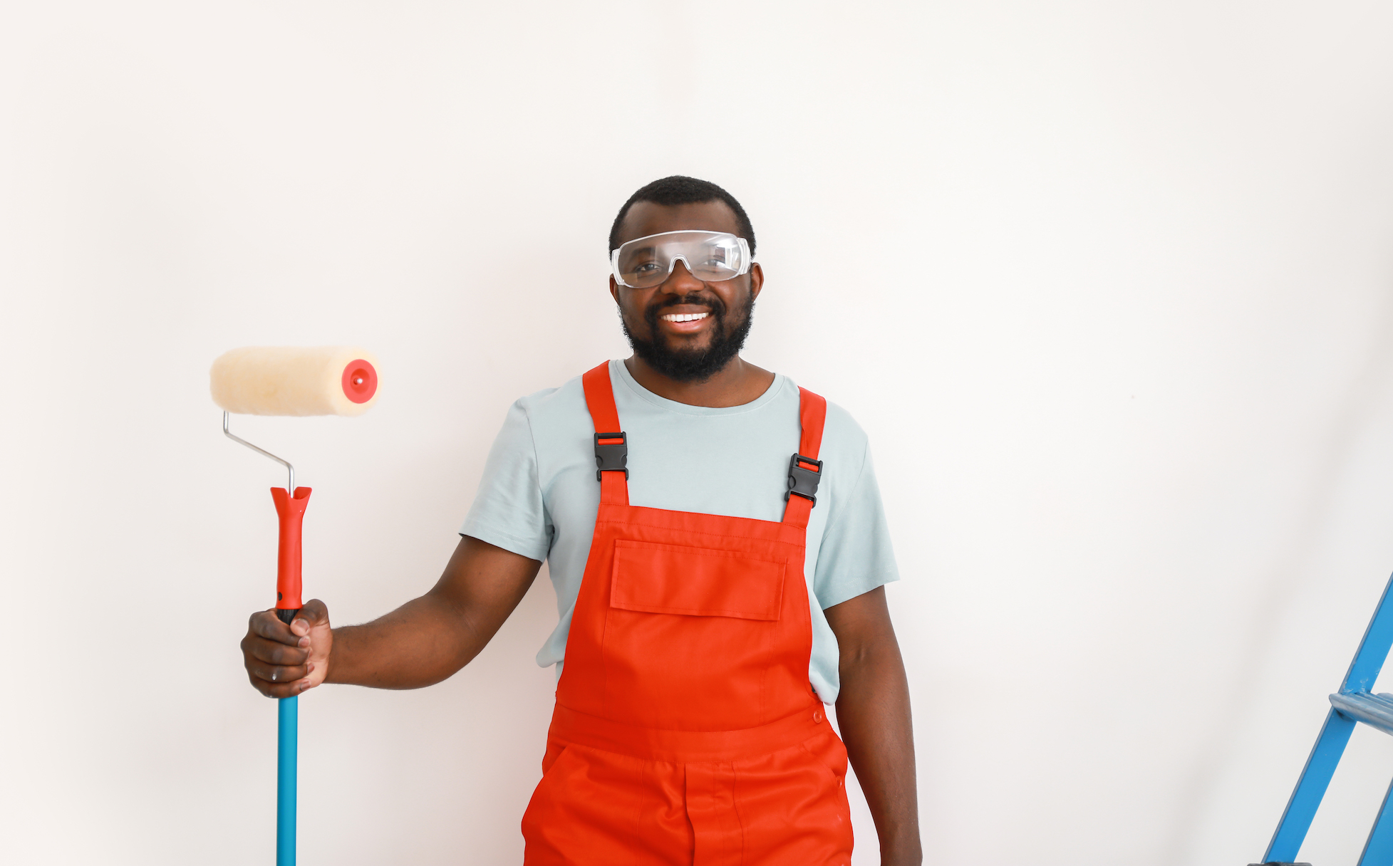 African-American painter near light wall